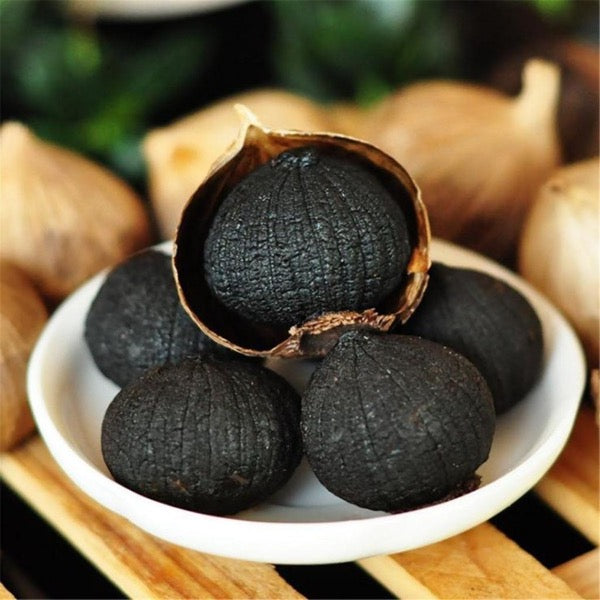 Black garlic in a 0.05kg pot from Sharbatly, showcasing dark, glossy cloves used as a flavorful vegetable ingredient.