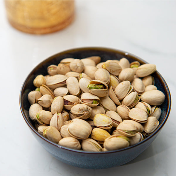 Roasted pistachios from Fresh Nuts in a 0.25 kg pack, showcasing green and tan nuts with shells intact.