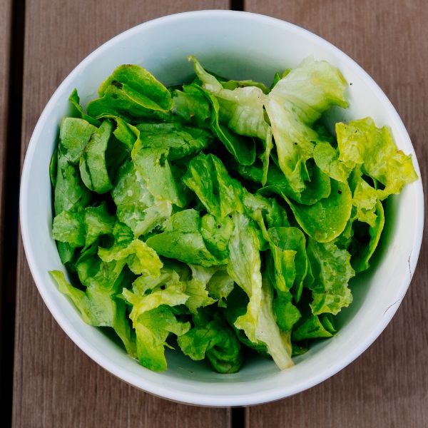 Fresh green Mizuna lettuce from Holland, a leafy mustard vegetable in a 0.125 kg pack, shown with vibrant green leaves.