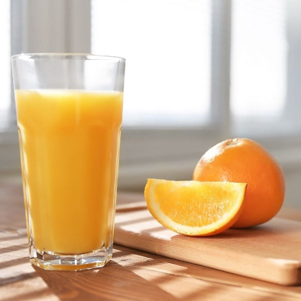 Fresh Valencia oranges for juice in a 6.5 kg carton, displayed in a basket with bright orange color and textured peel.