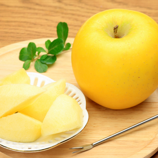 Fresh Golden Delicious apples from Sharbatly in a 4 kg carton, showcasing shiny yellow-green fruit with smooth skin.