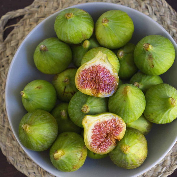 Fresh white figs from Sharbatly in a 1 kg carton, showcasing ripe, juicy fruit with green stems on a white background.
